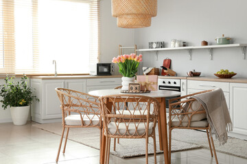 Calendar with date of International Women's Day, tulips and gift on dining table in kitchen
