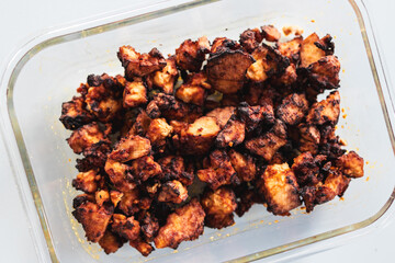 teriyaki marinated tofu chunks in glass container, close-up shot