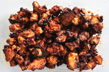 teriyaki marinated tofu chunks in glass container, close-up shot