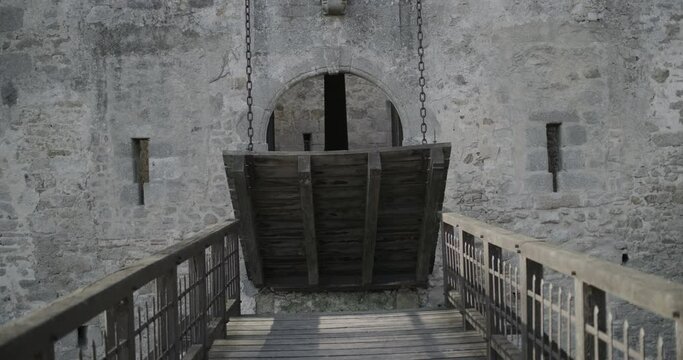 Draw bridge closing on ancient castle- wide, steady cam shot