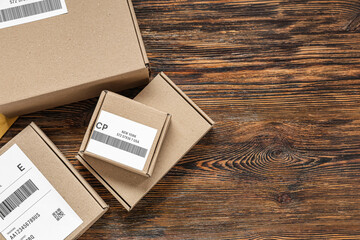 Cardboard packages with labels and barcodes on wooden table