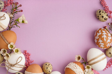 Easter eggs and flowers on purple background, closeup