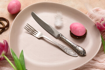 Table setting with Easter eggs, feathers and beautiful tulips on beige background