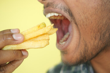 hungry man eating fries closeup