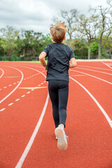 Youth male track team runner in first place running in a race 