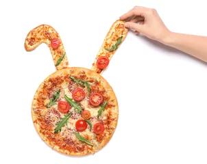 Keuken spatwand met foto Female hand decorating Easter pizza with bunny ears isolated on white background © Pixel-Shot