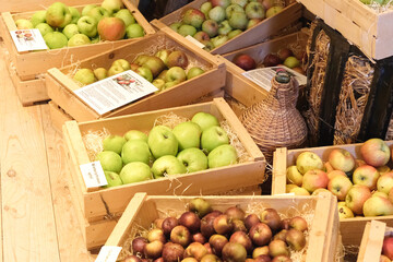 A bunch of apples are in wooden crates on a table