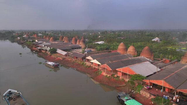 tBrick kilns and pottery kilns growing close together, from a distance, look like flaming towers under the sun, in Mang Thit, Vinh Long province, Viet Nam