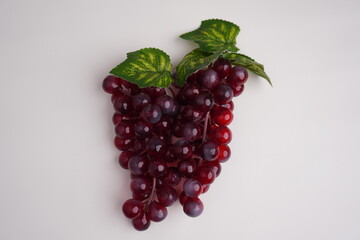 overhead shot of purple grapes with leaf on isolated white background