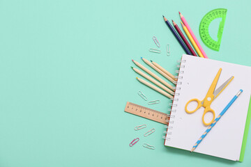 Notebook, pencil and scissors on turquoise background. Top view