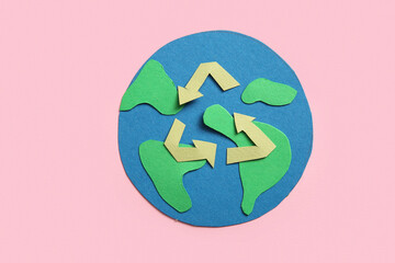 Felt planet Earth with ecology sign on pink background, closeup. Earth Day celebration.