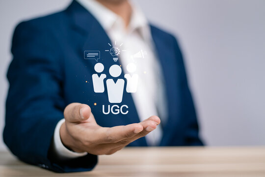 UGC, User generated content concept. Online marketing, Product reviews from the perspective of real users. Businessman holding UGC icon on virtual screen.