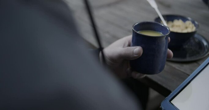 Close up reveal of cup of orange juice in man's hand