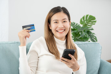 woman using smartphone for online shopping at home. Hand holding mobile phone with payment detail...