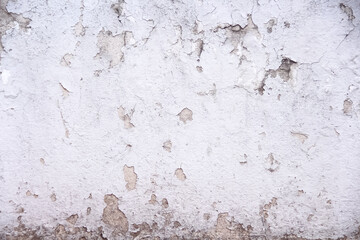 Old white concrete wall with peeling paint texture abstract on background