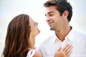 Couple, outdoor and smile with love, sky and eye contact on summer holiday with connection in nature. Man, woman and trust for bonding, romance or relationship with memory on vacation in Mykonos