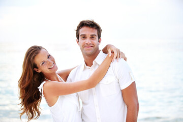 Fototapeta premium Happy couple, portrait and hug by ocean in nature, support and relax on honeymoon adventure in outdoor. Young man, woman and face or bonding in marriage, sea and travel on summer holiday in cape town