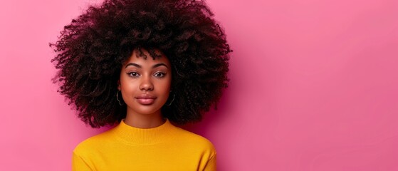   Close-up portrait of a woman in a yellow shirt with a large afro hairstyle on a pink background