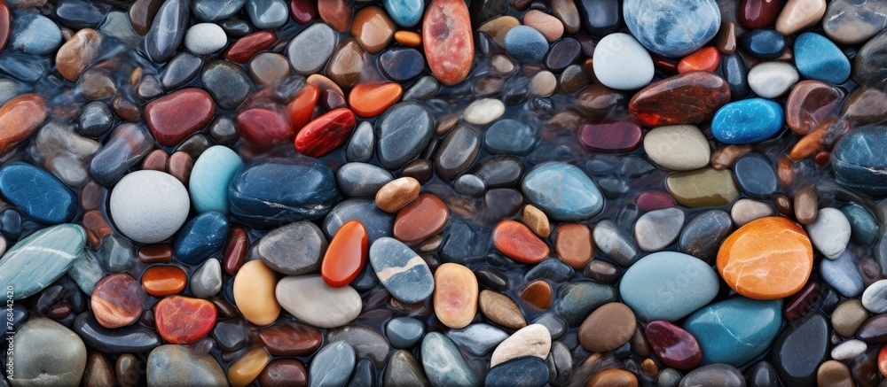 Poster A close-up view of a collection of assorted stones and tiny pebbles scattered on a sandy beach