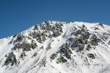 Szczyty otaczające Czarny Staw Gąsienicowy w polskich Tatrach sfotografowane w słoneczny zimowy dzień.