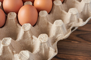 Eggs in a cardboard box on a wooden background. Close-up.