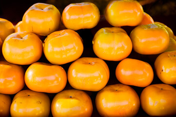 Pile of persimmons. Stock of persimmons. Background of persimmons. Organic persimmon fruit.