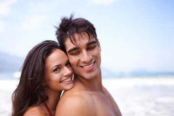 Love, hug and portrait of happy couple at beach for tropical holiday adventure, relax and bonding together. Nature, man and woman smile on romantic date with ocean, blue sky and embrace on vacation.