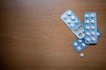 Top view of tablets pills drugs on wooden table. Medicine concept