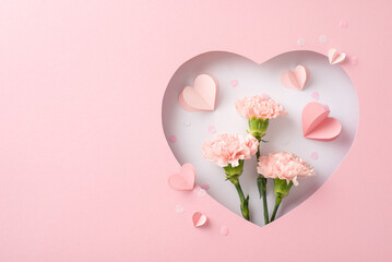 Mother's Day charm concept. Top view of fresh cloves, hearts, and delicate confetti, framed by a silhouette of heart on soft pink backdrop, providing space for heartfelt greetings or advertisements © ActionGP