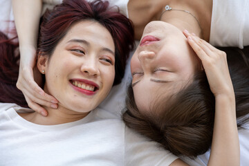 Warm and Intimate Moment: Young Asian  Lesbian Partners Sharing Love and Happiness Together on the bed at Home 