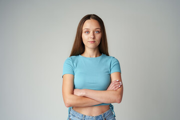 Portrait of smiling young woman in blue T-shirt on gray background