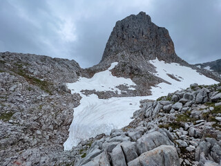 A hike though the Berchtesgaden landscape during summer with rain clouds and remaining snow fields