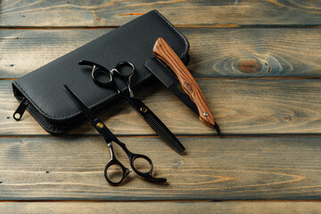 Hairdressing professional scissors on wooden background close up