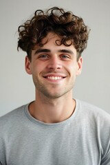 Portrait of a handsome young man with curly hair smiling at camera