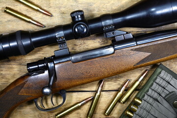 Hunting rifle and ammunition on a  wooden background.Top view.