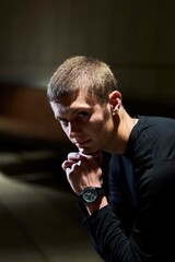 A handsome young guy in black clothes at night in the park.