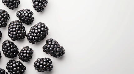 A cluster of juicy blackberries scattered on a white surface.