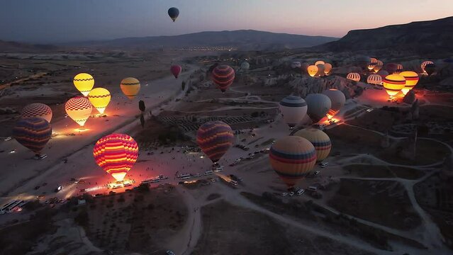 Hot air balloons in cappadocia at dusk at dawn getting ready to take off. This video showcases the enchanting spectacle of a hot air balloon festival. Cappadocia, Turkey