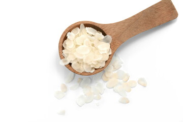 flattened rice flakes in a wooden spoon isolated on white.