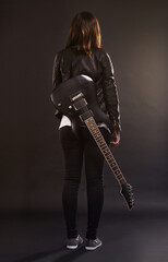 Fototapeta premium Woman, guitar and fashion for musical instrument, sound and trendy for retro and style on dark background. Young person or musician for creative, funky and edgy for bold with leather jacket for rock