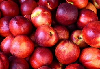 A beautiful fragrant ripe nectarine, the view from the top. Nectarines in the market. A group of colorful nectarine fruits on a market.