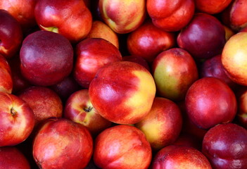 A beautiful fragrant ripe nectarine, the view from the top. Nectarines in the market. A group of colorful nectarine fruits on a market.