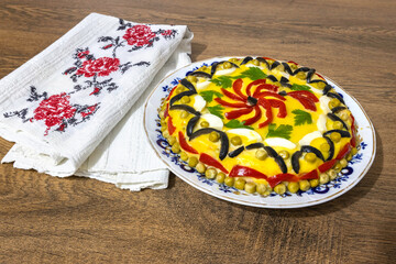 Traditional Romanian boeuf (beef) salad decorated for Christmas or Easter with a traditional towel on a wooden table