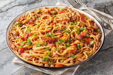 Cowboy spaghetti is made with fire-roasted tomatoes, ground beef, bacon, and cheddar cheese closeup...