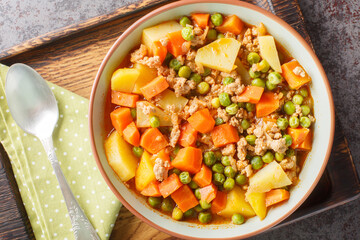 Turkish rustic Kiymali bezelye Mince and Pea Stew closeup on the plate on the table. Horizontal top view from above