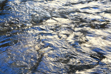 Long exposure smooth flow of water streaming fast In daylight. Abstract landscape
