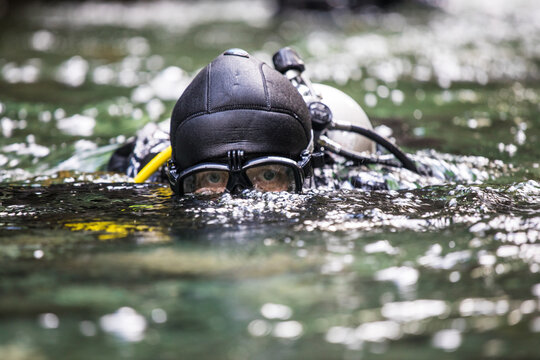 Suba diver surfaces after a dive, goggles protecting eyes