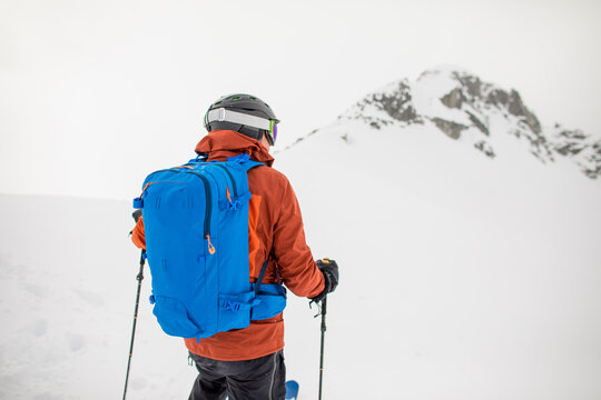 Rear view of backcountry skier approaching mountain summit