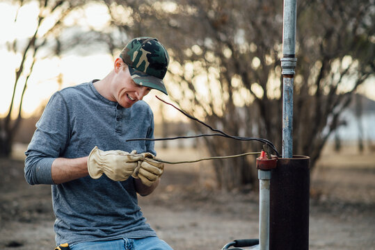 Close up of man smiling while doing electrical work outside