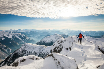 A mountaineer approaches the summit of a mountain in winter